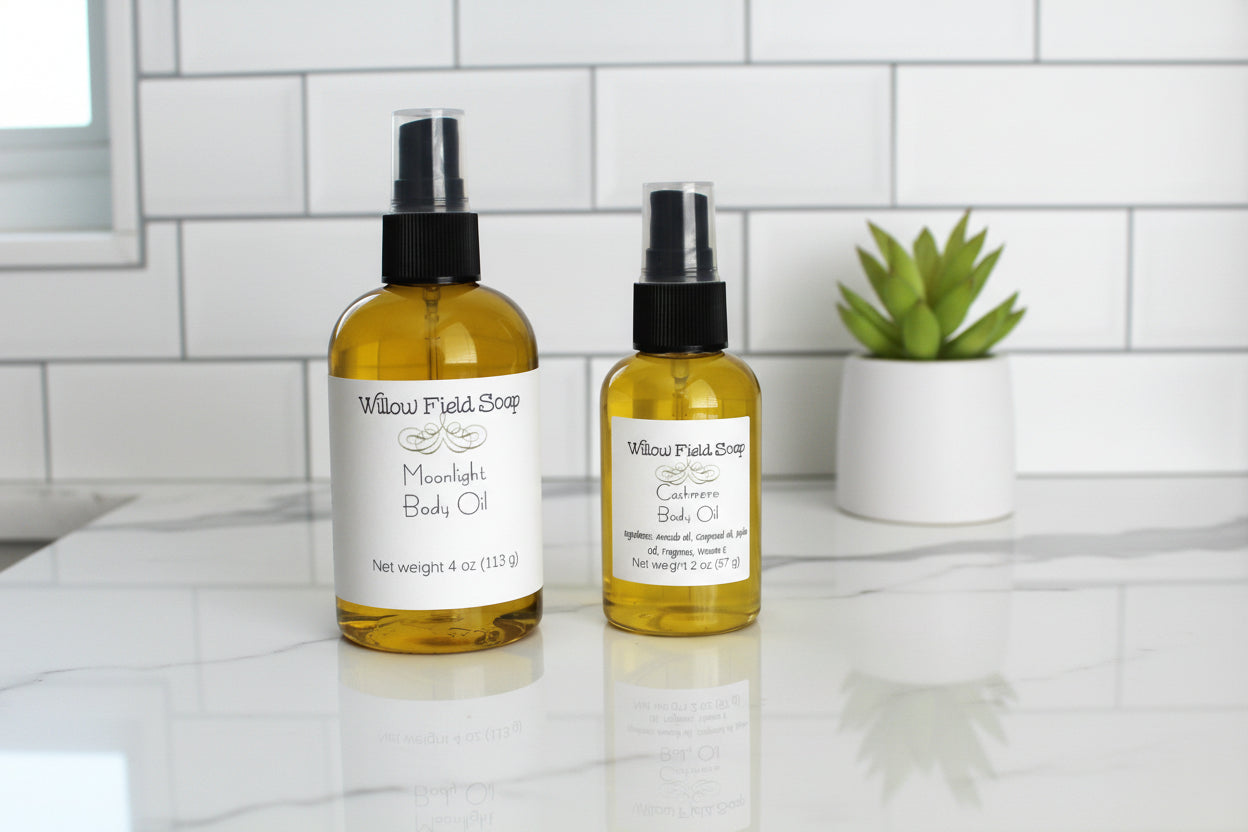 Two bottles of Willow Field Soap body oils on a white surface with a tiled wall background.