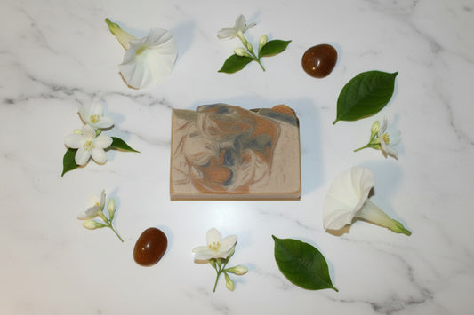 Soap bar with flowers and leaves on a marble surface